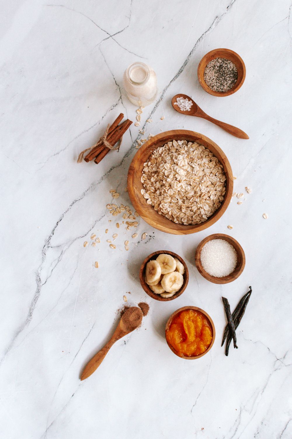 Pumpkin overnight oatmeal ingredients with rolled oats, canned pumpkin, pumpkin pie spice, chia seeds, and banana.