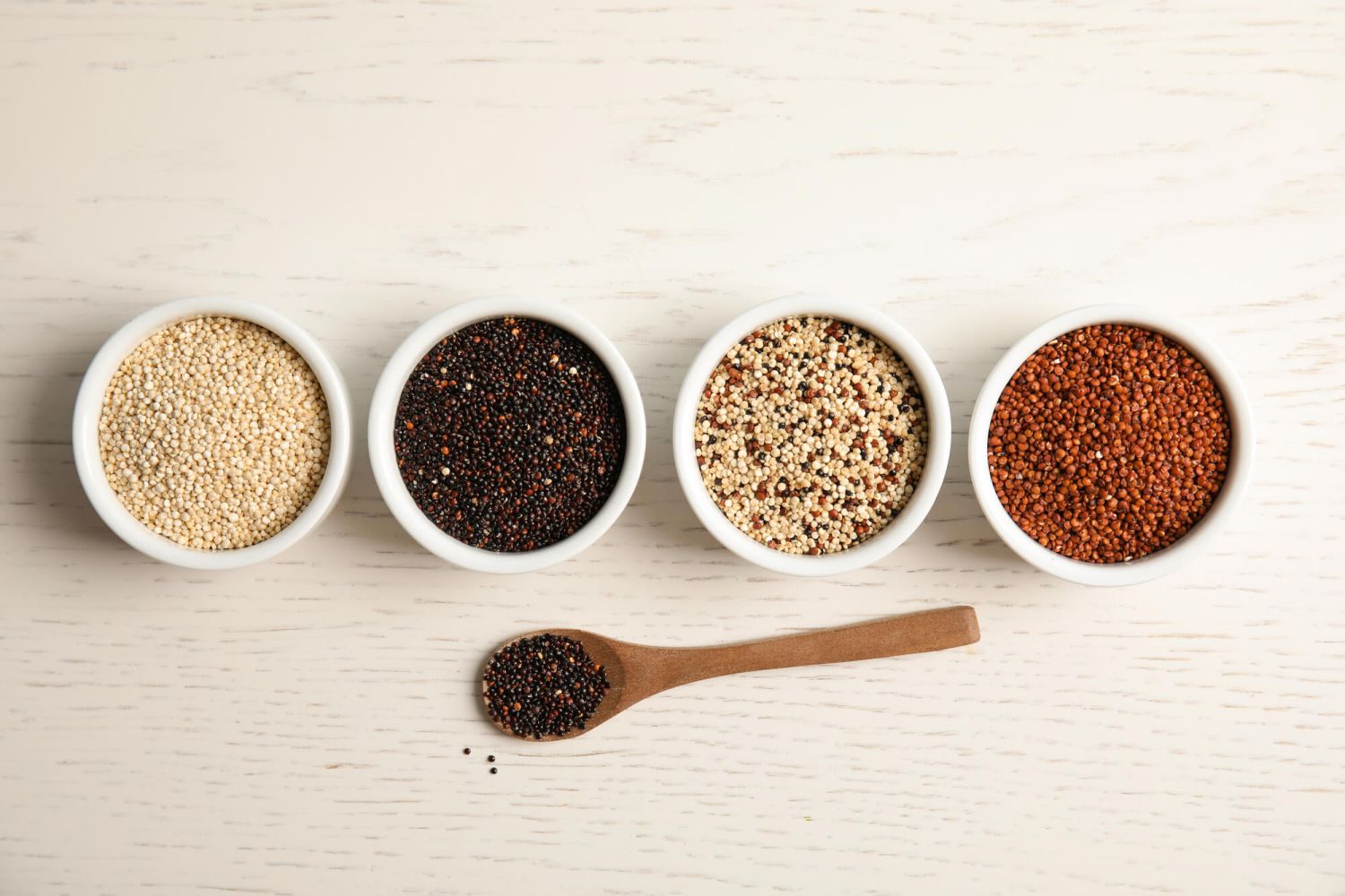 Types of quinoa in wooden spoons including white, red, black, and tricolor.jpg