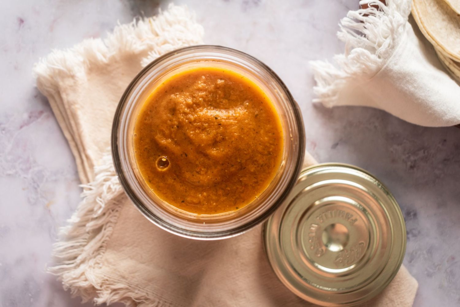 Mexican ranchero sauce with chipotle peppers, jalapeno, tomatoes, onion, and garlic blended in a glass container.