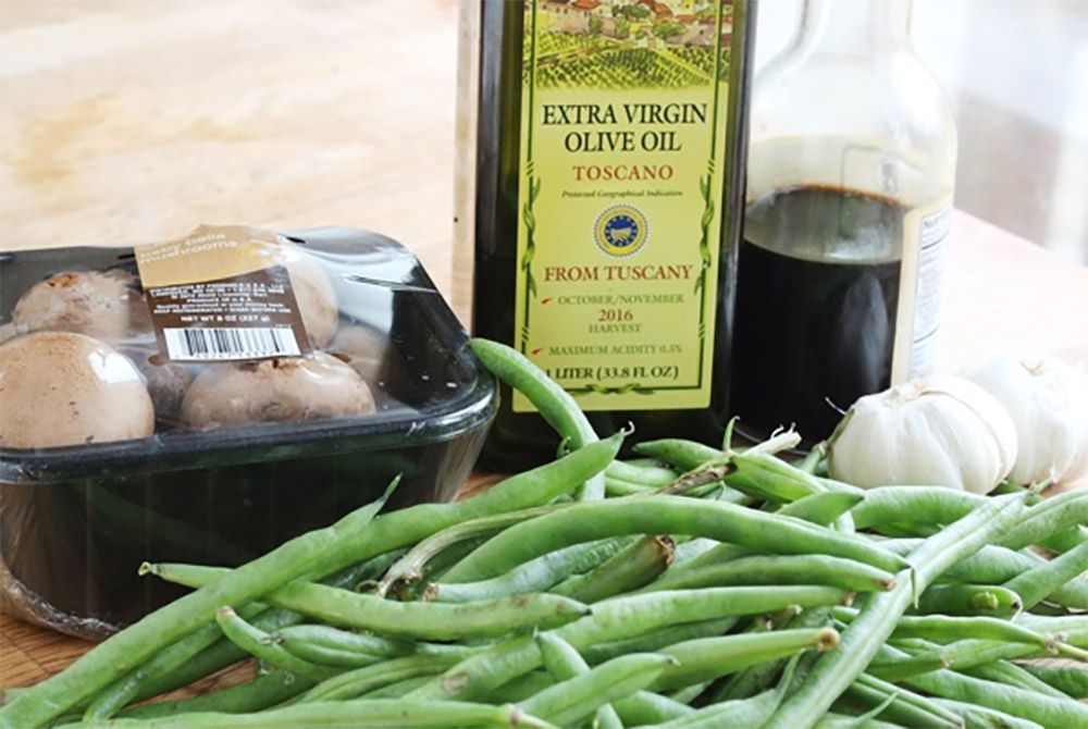 Roasted green beans and mushrooms ingredients on a cutting board.