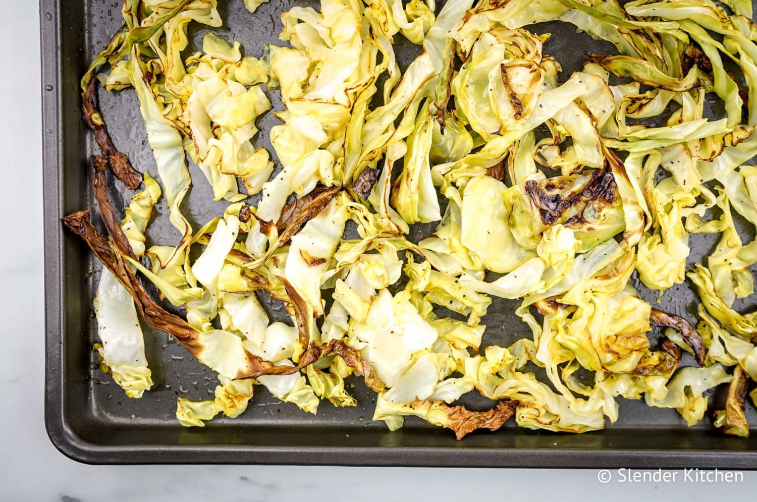 Roasted cabbage on a sheet pan with crispy edges.