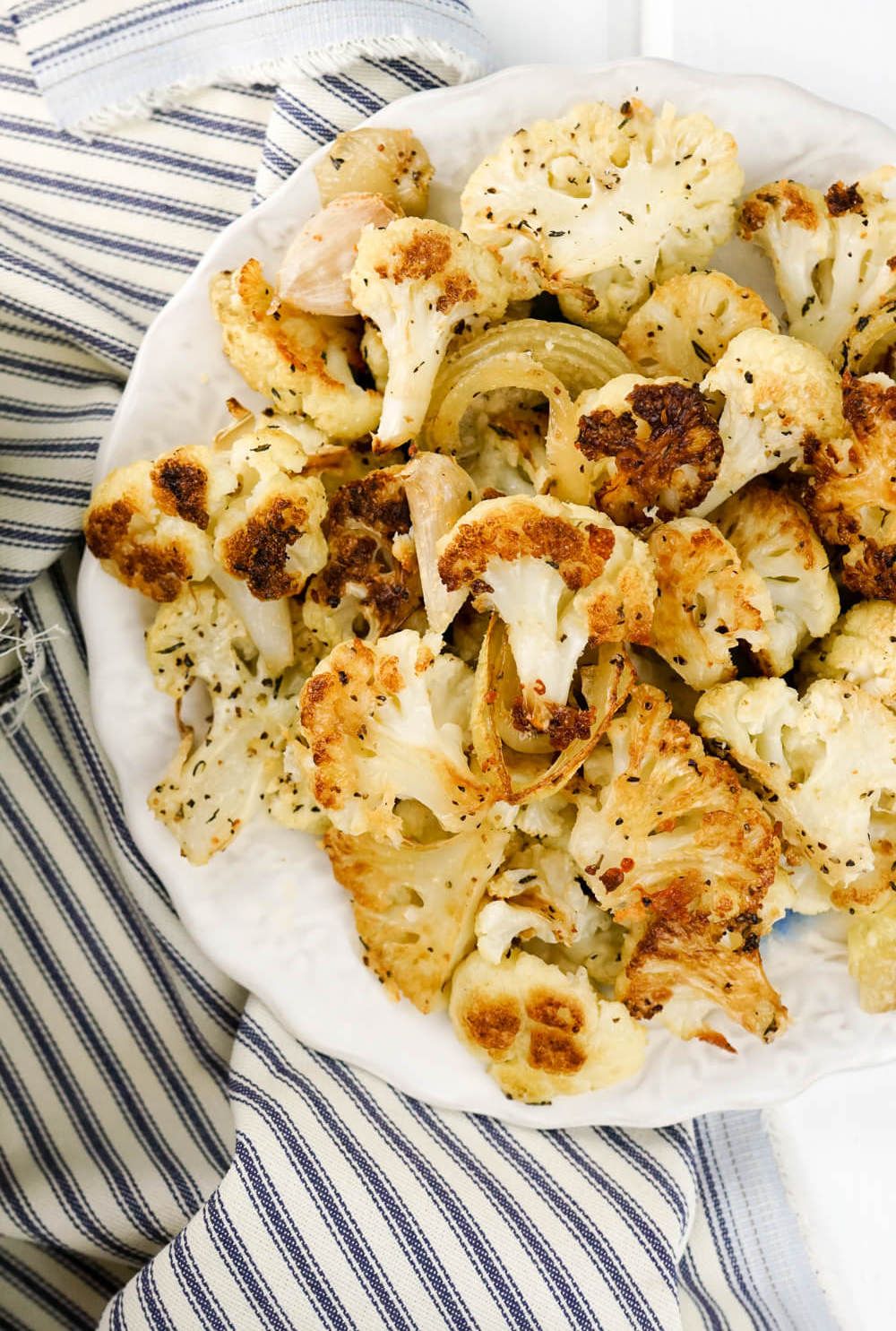 Frozen Roasted Vegetables including cauliflower on a plate with Parmesan cheese.