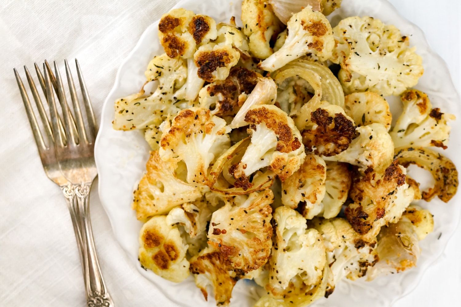 Parmesan Roasted Cauliflower covered in cheese and cooked with onions, garlic, and thyme.