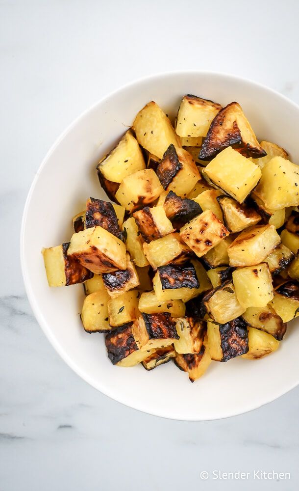 Roasted turnips with caramelized edges in a white bowl with salt and pepper.