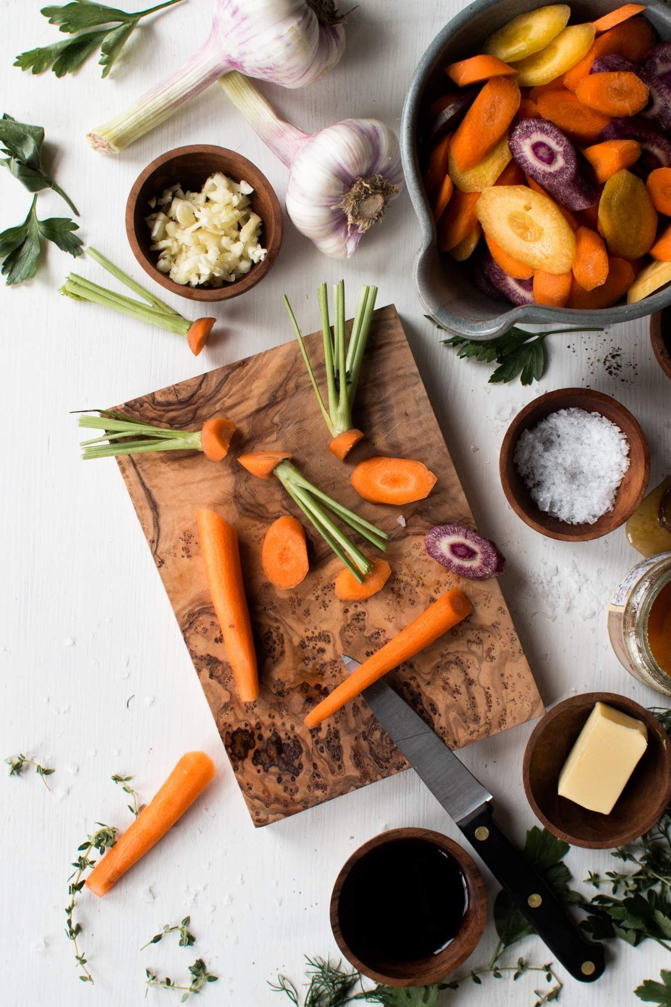 Ingredients for sauteed carrots including carrots, honey, balsamic, butter, salt, and fresh herbs.