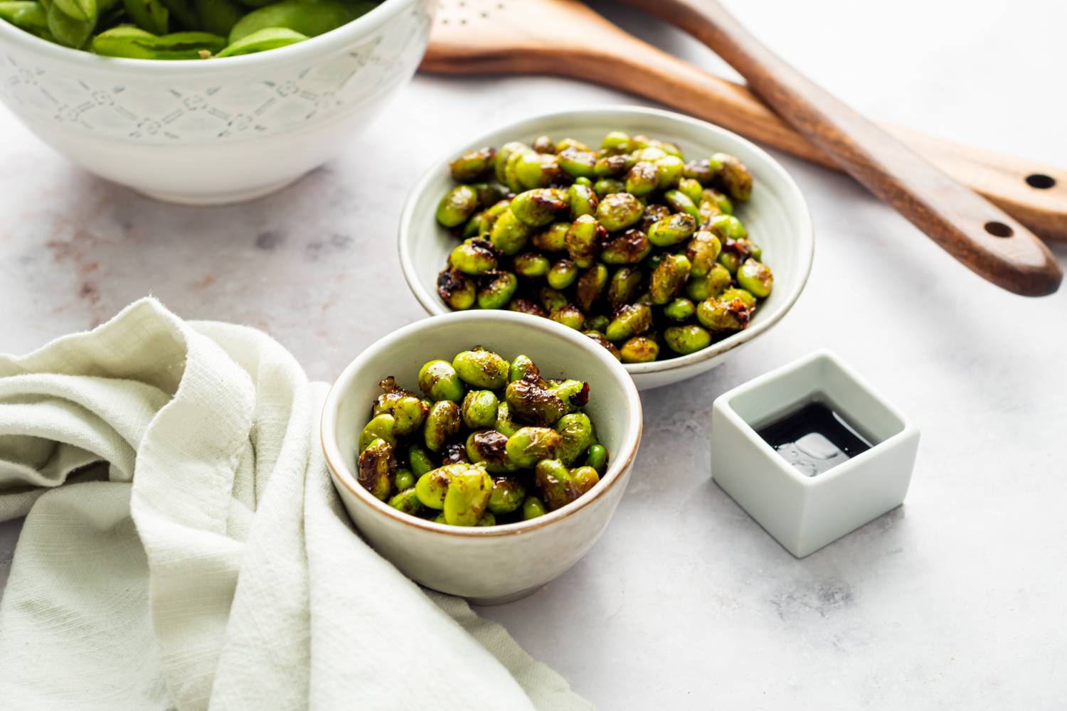 Edamame soy beans with browned edges served with soy sauce.