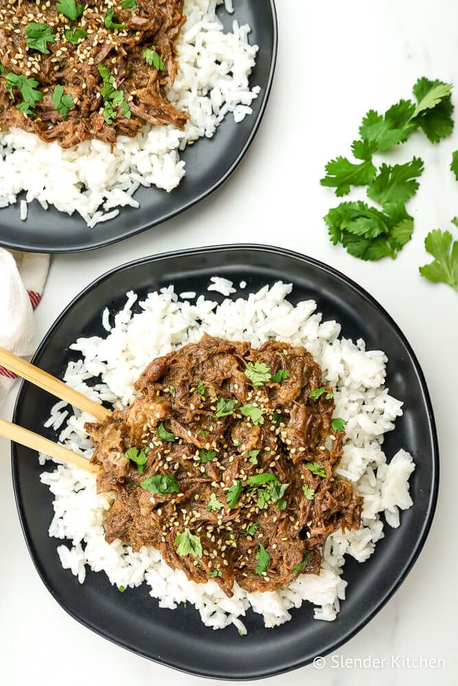 Sesame beef over rice with cilantro and sesame seeds.