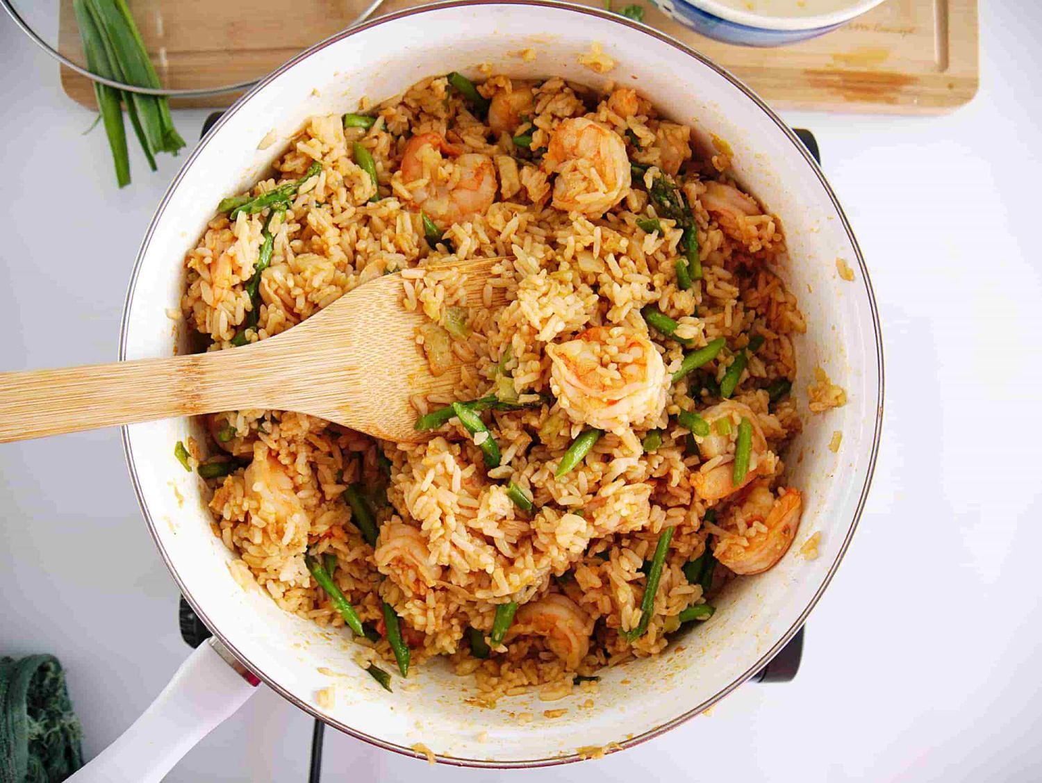 Fried Rice with Shrimp with asparagus, lime, and a wooden spoon.