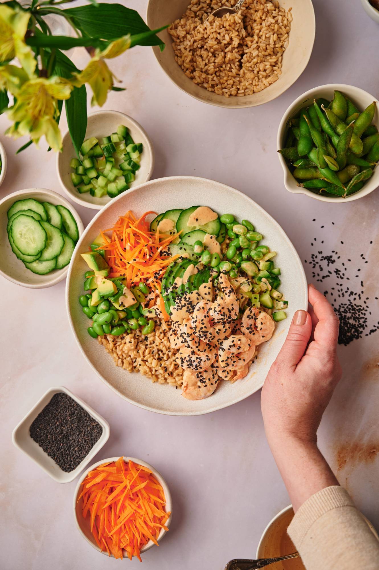 Sushi bowl with shrimp tossed in spicy mayo wit avocado, cucumber, edamame, carrots, and brown rice.