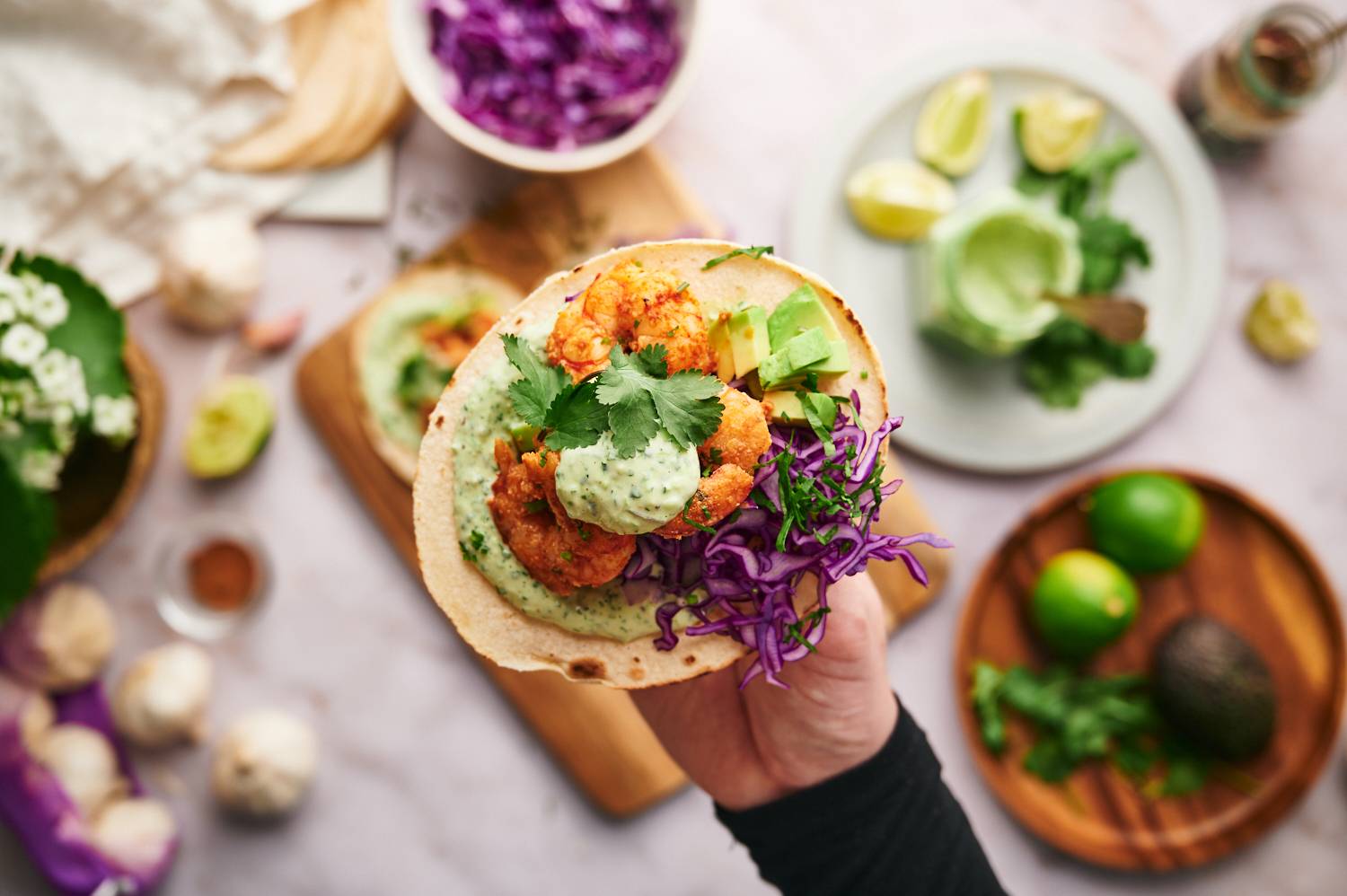 Easy shrimp tacos with a homemade spice rub on a corn tortilla with creamy cilantro sauce and cabbage.