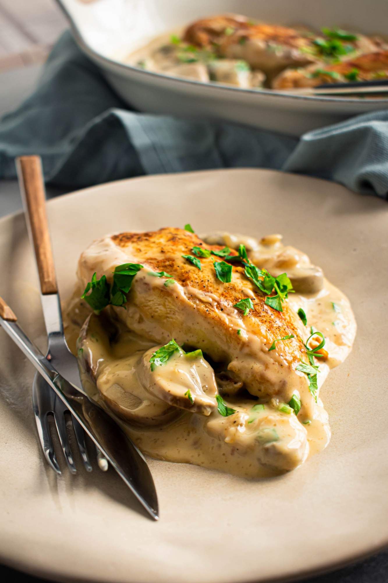 Crockpot chicken marsala on a plate with browned chicken breast covered in a creamy marsala mushroom sauce.