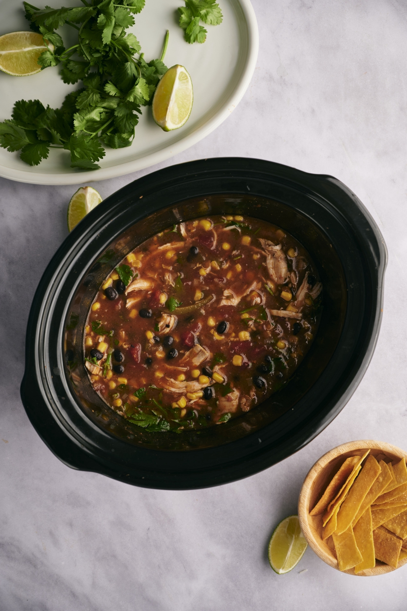 Chicken tortilla soup made in the slow cooker with chicken breast, tomatoes, black beans, corn, and cilantro.