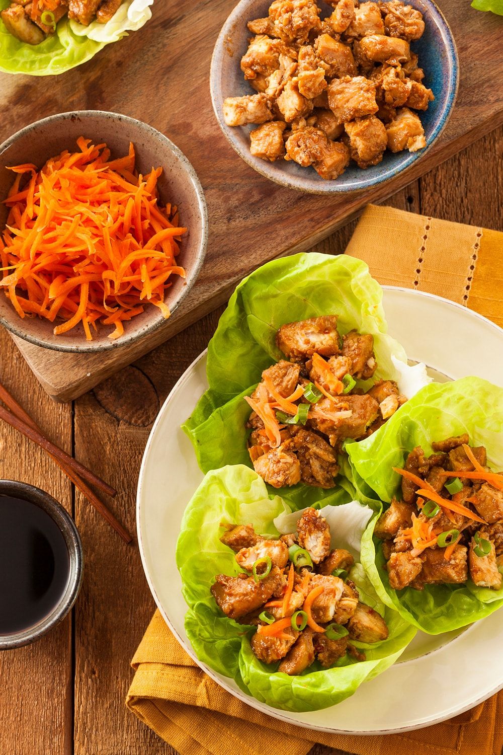 Slow Cooker Korean Chicken served in lettuce wraps with carrots.