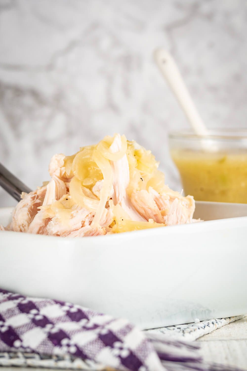 Lemon garlic chicken in a bowl with sauce on the side.