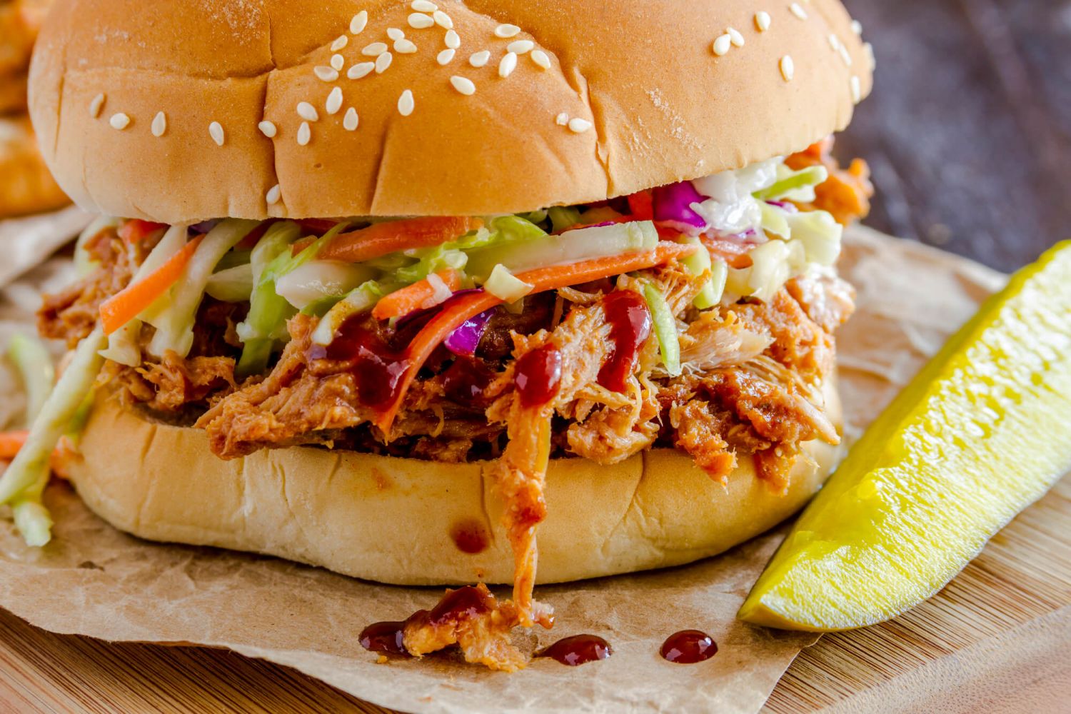 Slow Cooker Barbecue turkey in a sandwich bun with coleslaw and a pickle.