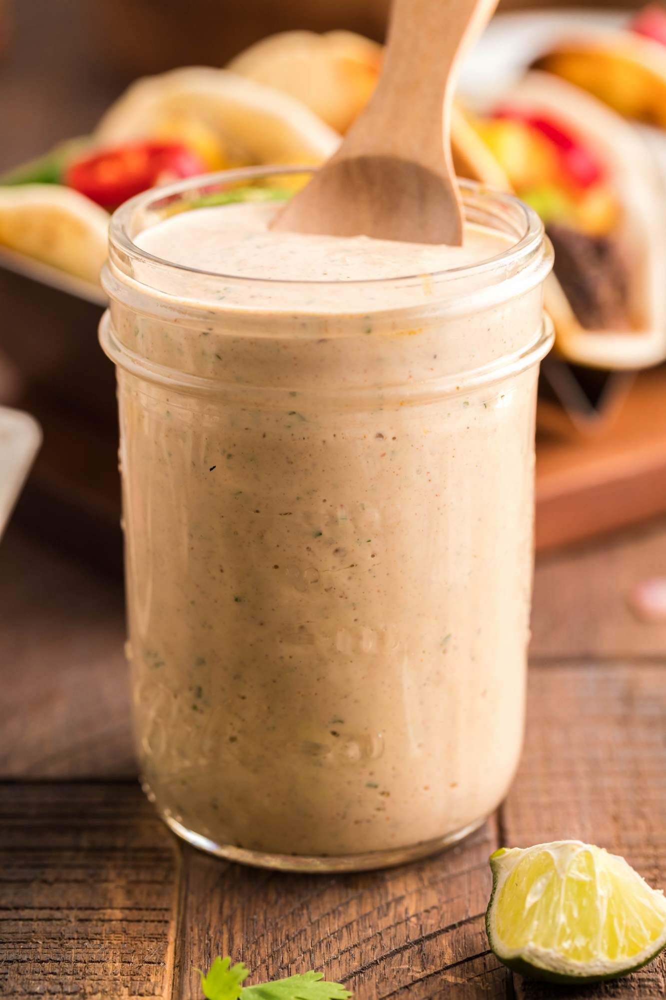 Creamy southwest dressing in a glass jar with taco seasoning, jalapenos, and lime juice.