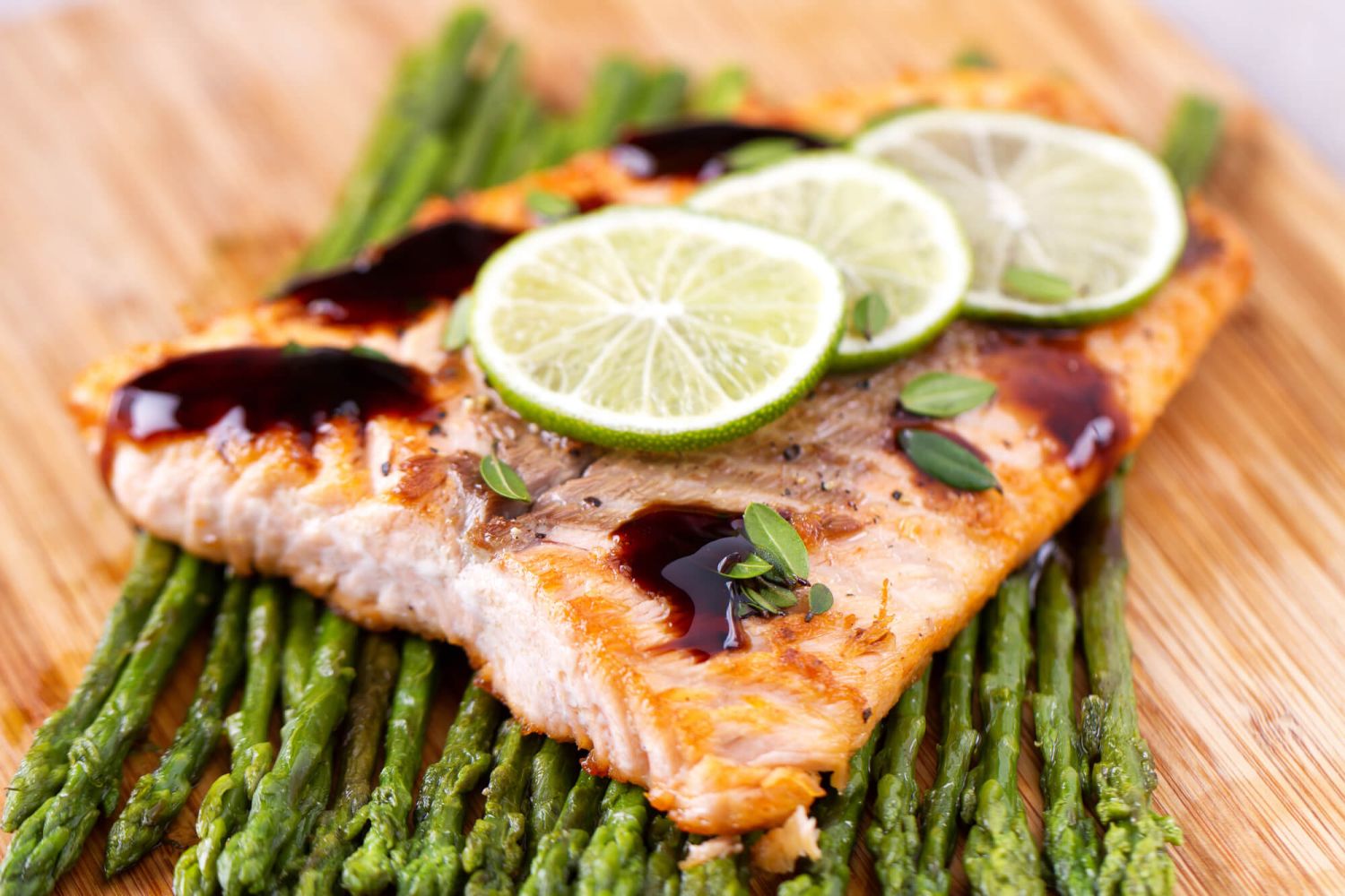 Baked Spicy salmon on a cutting board with asparagus.