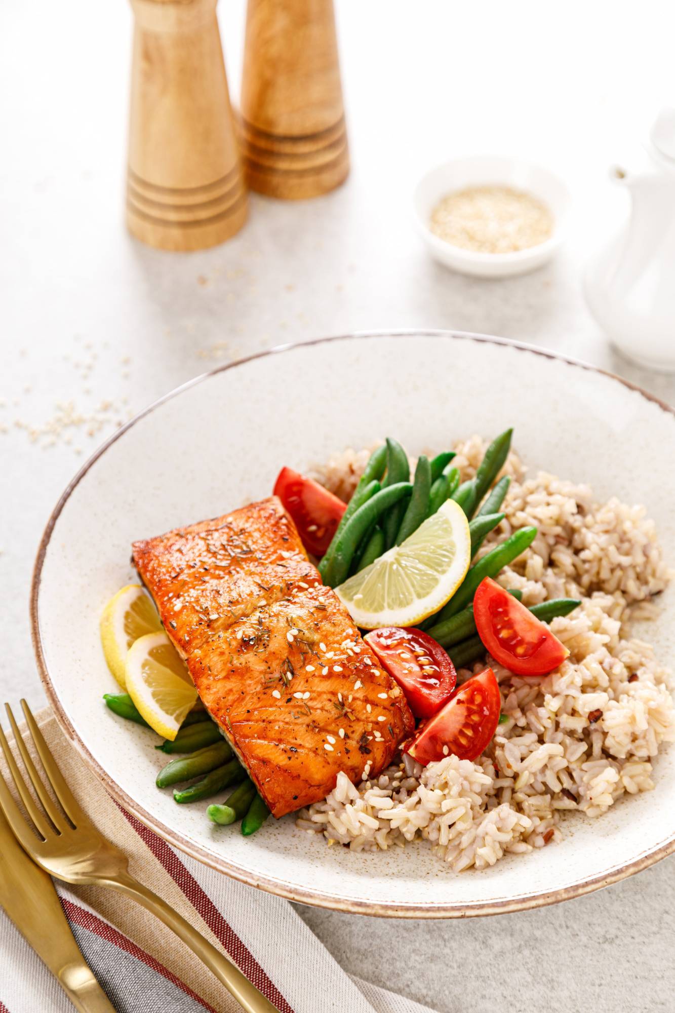 Baked spicy salmon served with green beans, tomatoes, and wild rice in a bowl.