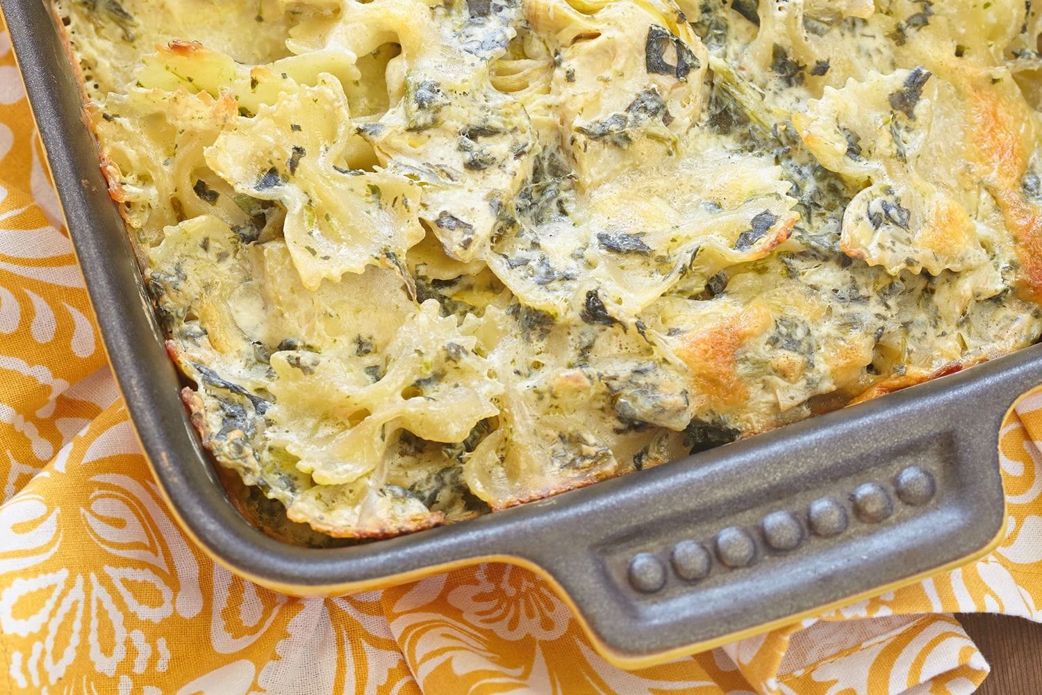 Spinach Artichoke Pasta with a yellow floral napkin.