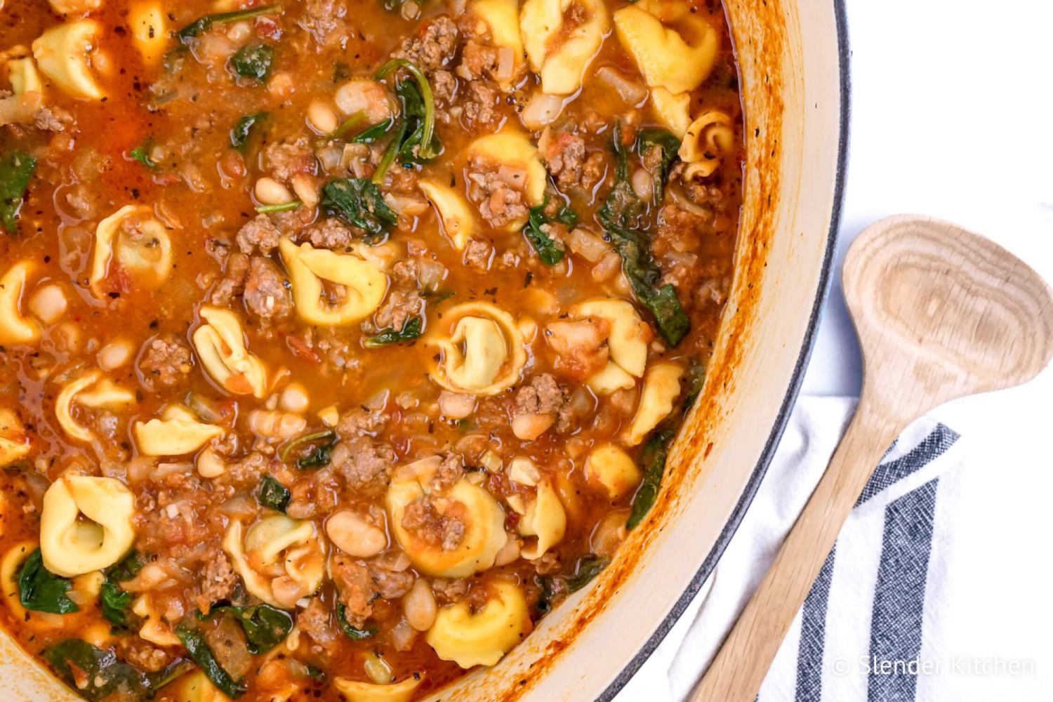 Tortellini soup with spinach and ground turkey in tomato broth in a large pot/