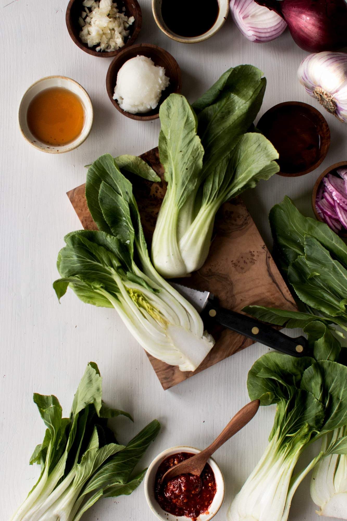 Bok choy for stir fry with coconut oil, red pepper flakes, and soy sauce in small bowls.