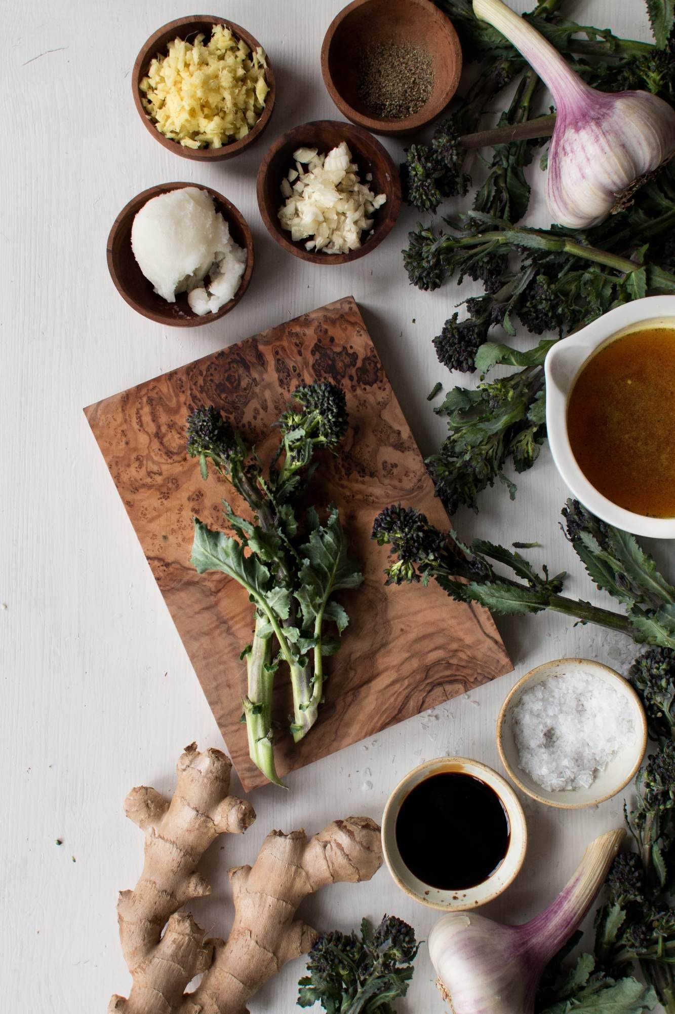 Ingredients for stir fried Chinese broccoli including broccoli, garlic, soy sauce, ginger, and coconut oil.