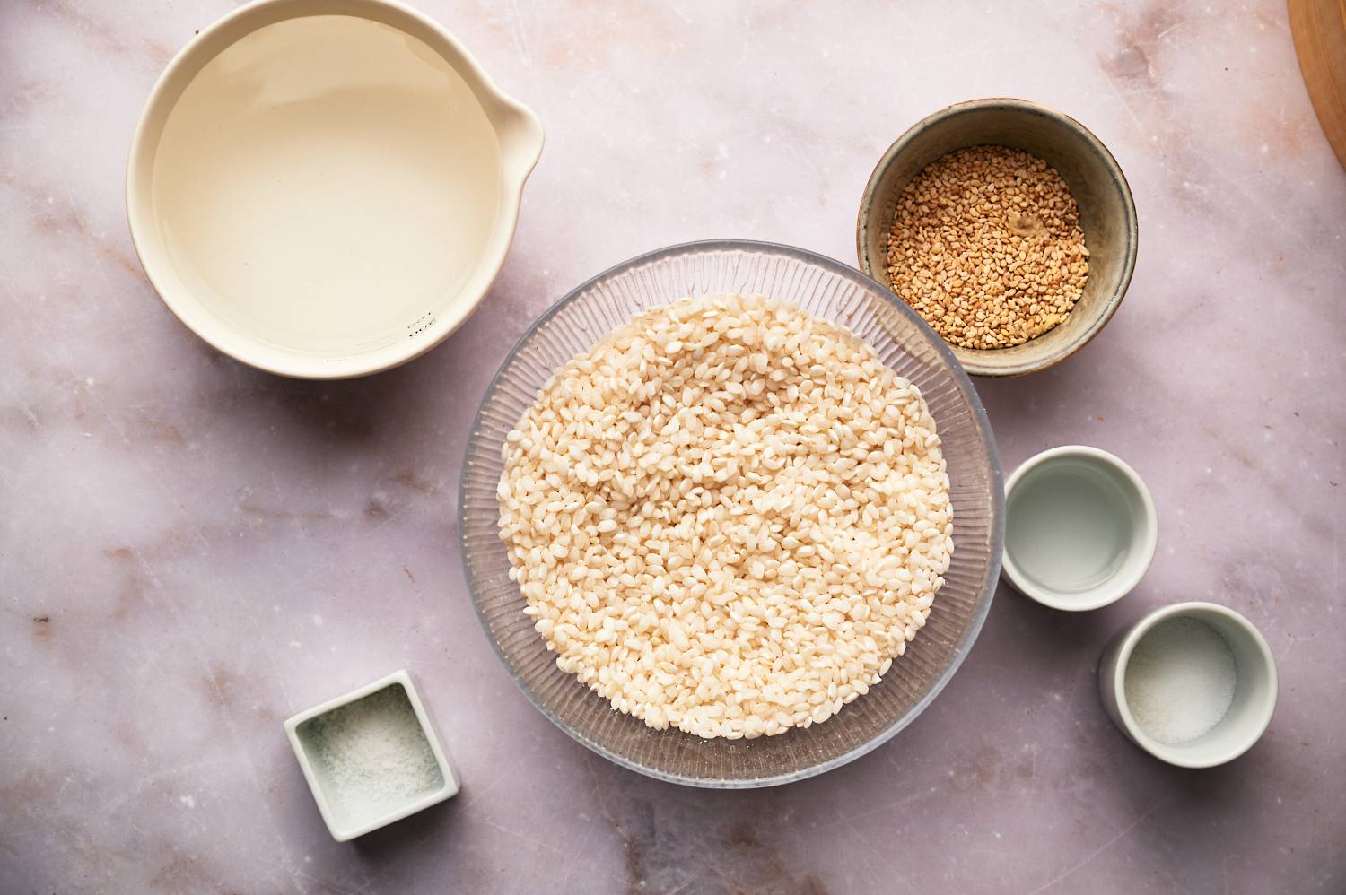 Ingredients for sushi rice including short grain Japanese rice, water, salt, sugar, and rice vinegar.