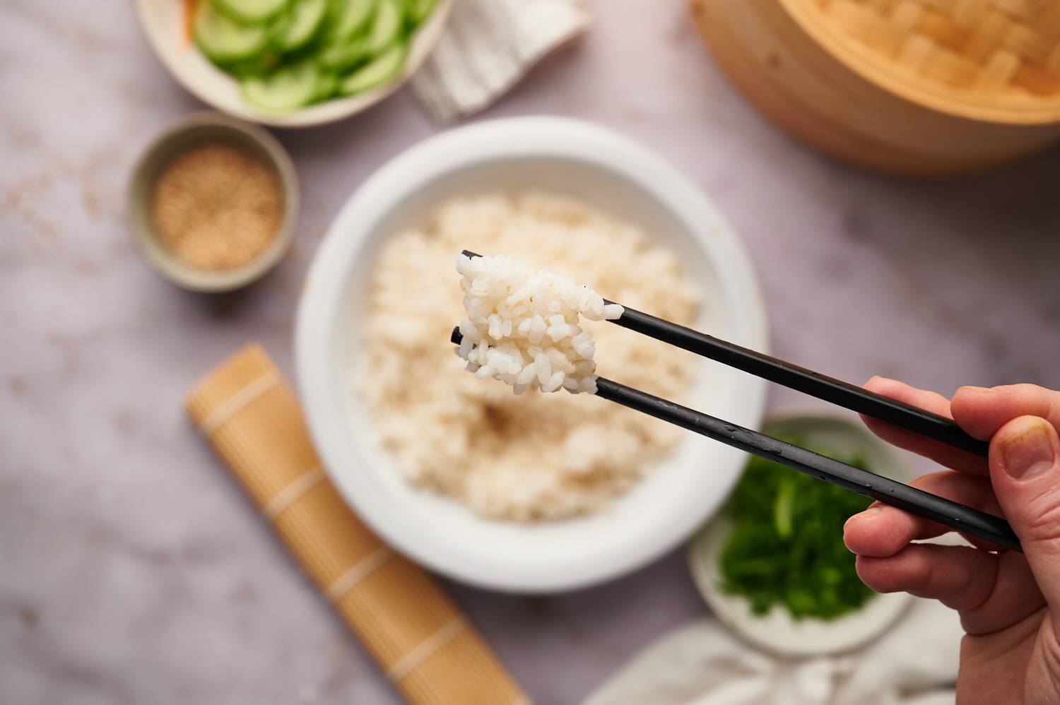 Chopsticks holding up sushi rice.