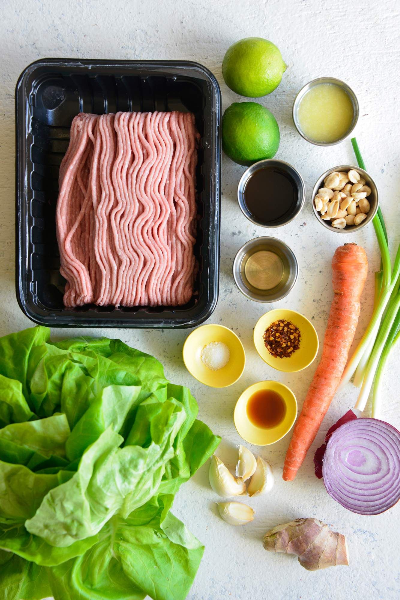 Ingredients for Thai turkey lettuce wraps including ground turkey, soy sauce, brown sugar, carrots, cilantro, and onions.