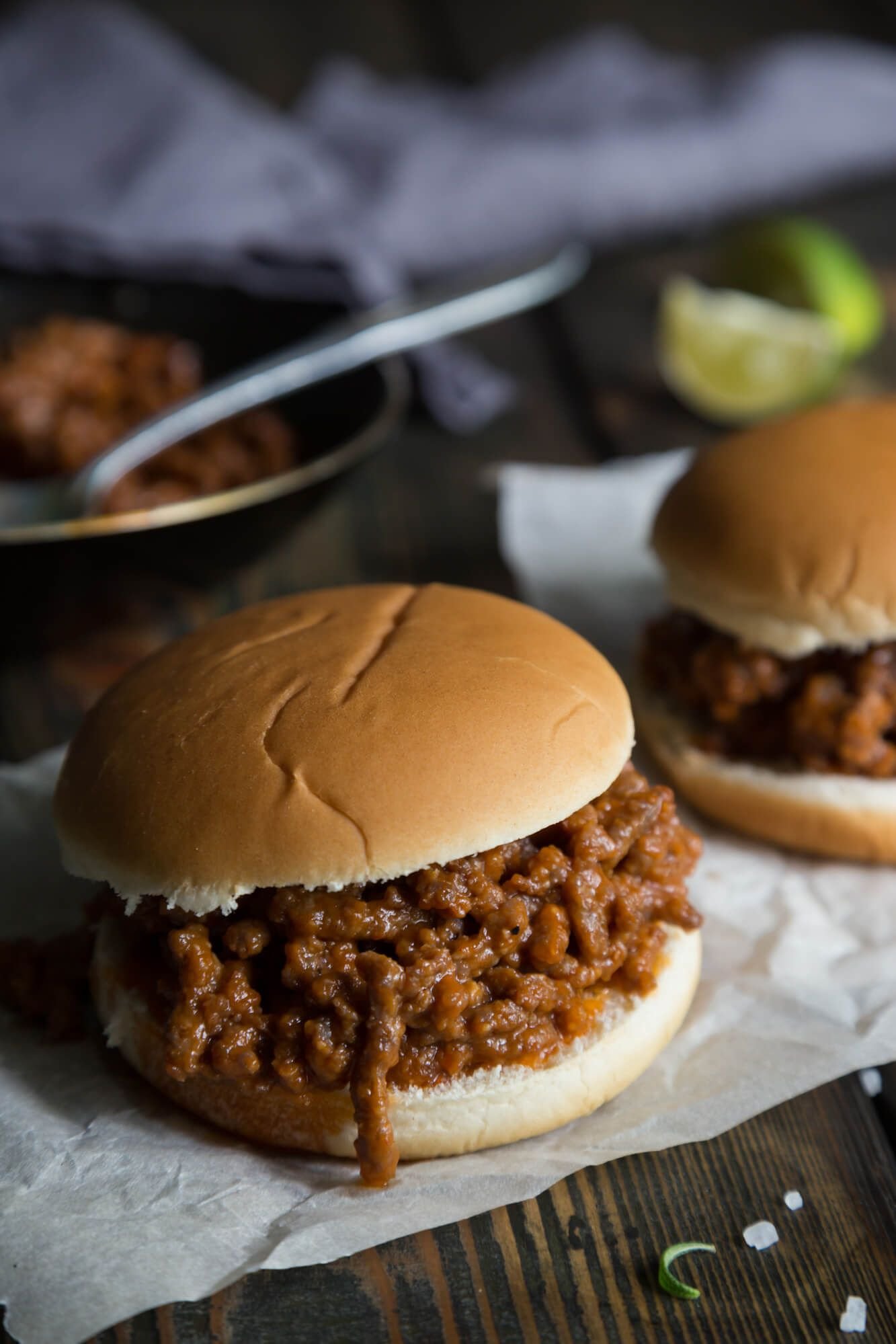 Sloppy Joes in a thick sauce in two hamburger buns with a skillet.