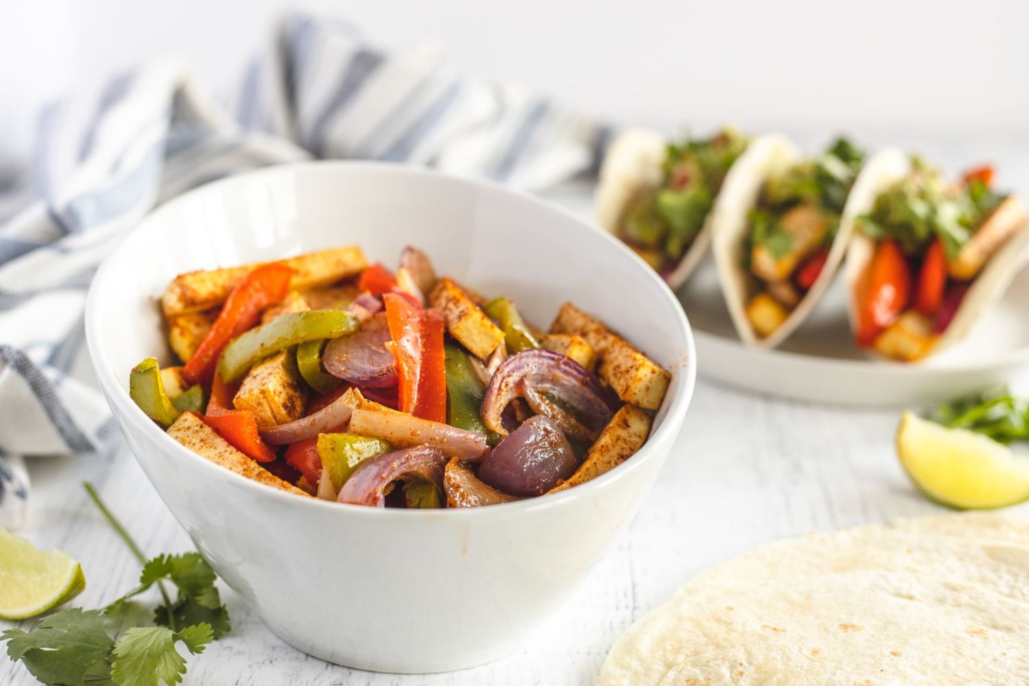 Baked tofu fajitas with homemade fajita seasoning, bell peppers, and onion in a bowl.