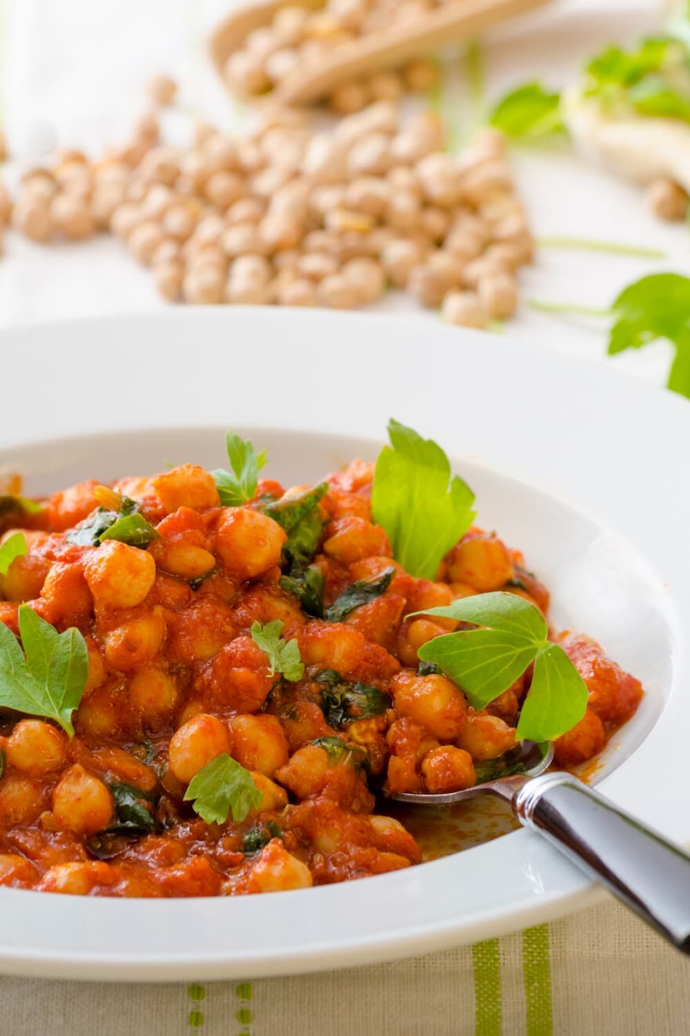 Curry chickpea stew with tomatoes, spinach, and chickpeas in a bowl with cilantro.