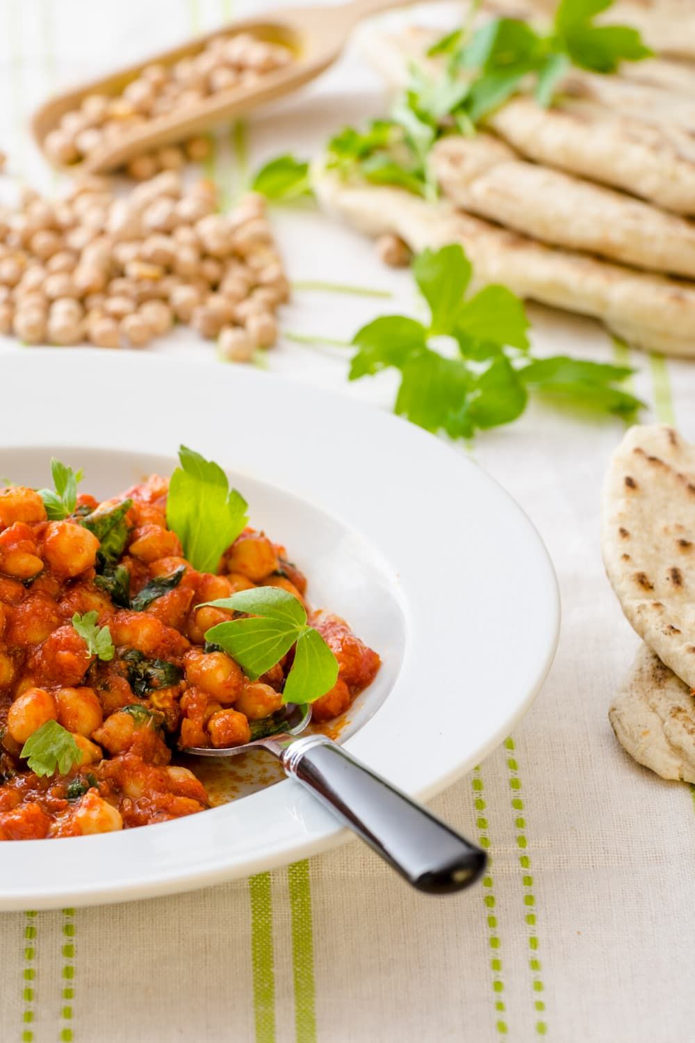 Tomato curry coconut chickpea stew with spinach, potatoes, and cauliflower in a bowl.