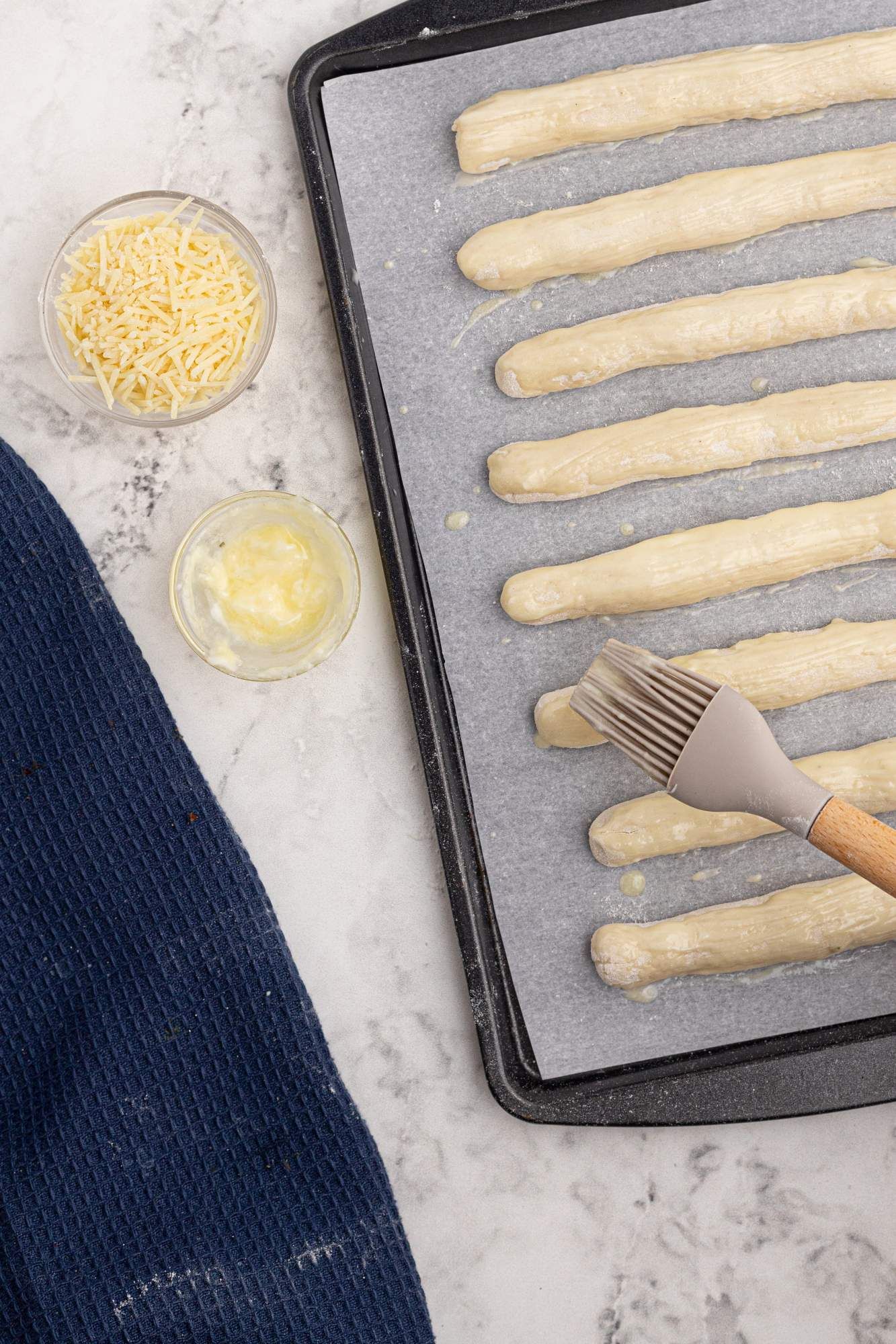 Greek yogurt breadsticks with two ingredient dough on a baking sheet before being baked.