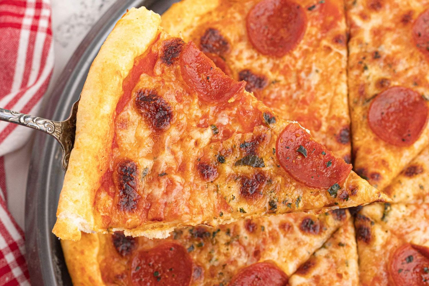 Greek yogurt pizza dough topped with tomato sauce, mozzarella cheese, and pepperoni cut into slices.