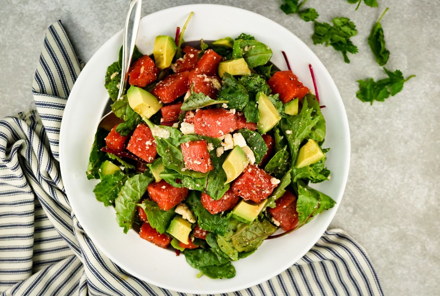 Watermelon and Avocado Salad with Honey Lime Vinaigrette with feta and greens.