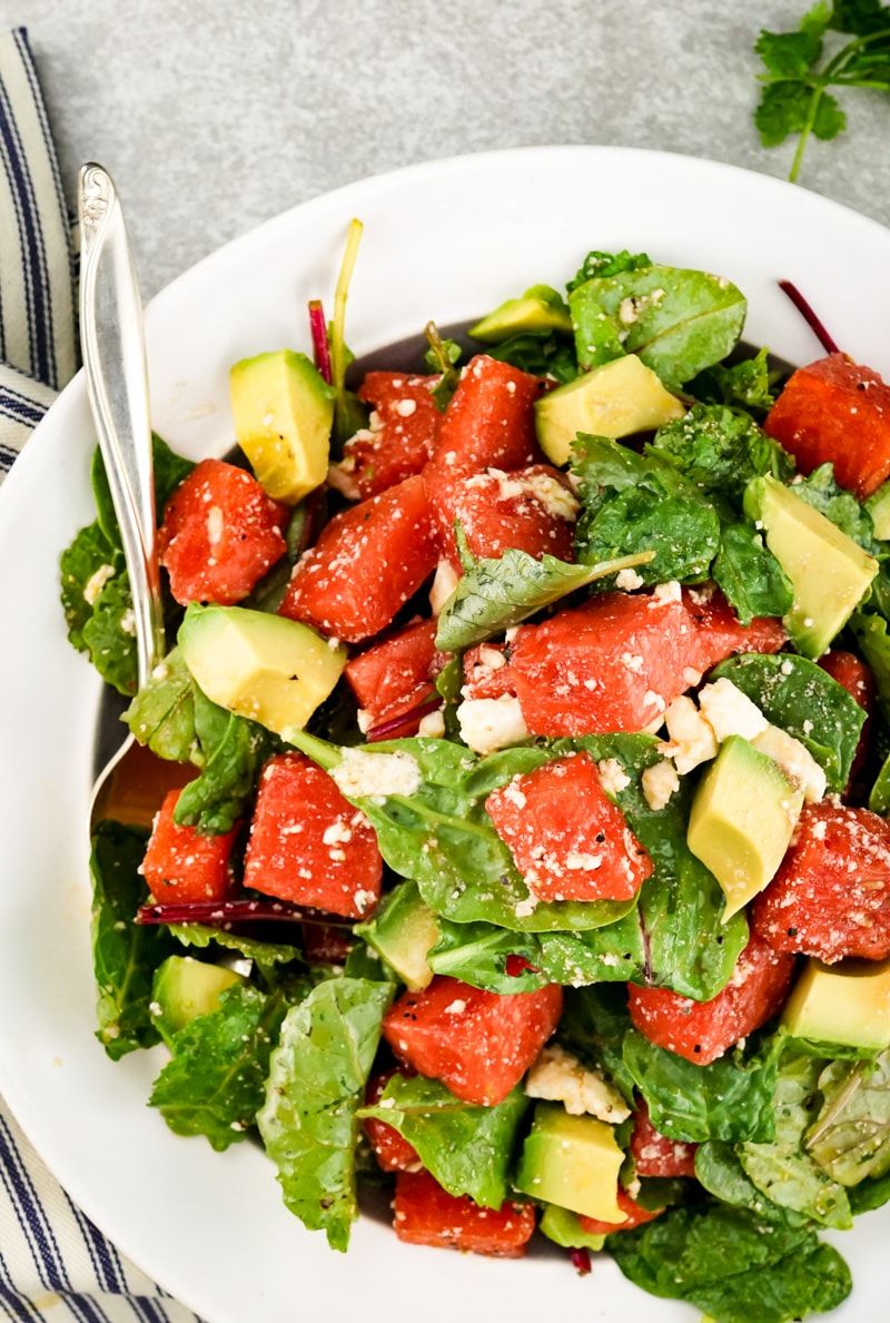 Watermelon and Avocado Salad with Honey Lime Vinaigrette with creamy feta cheese and greens.