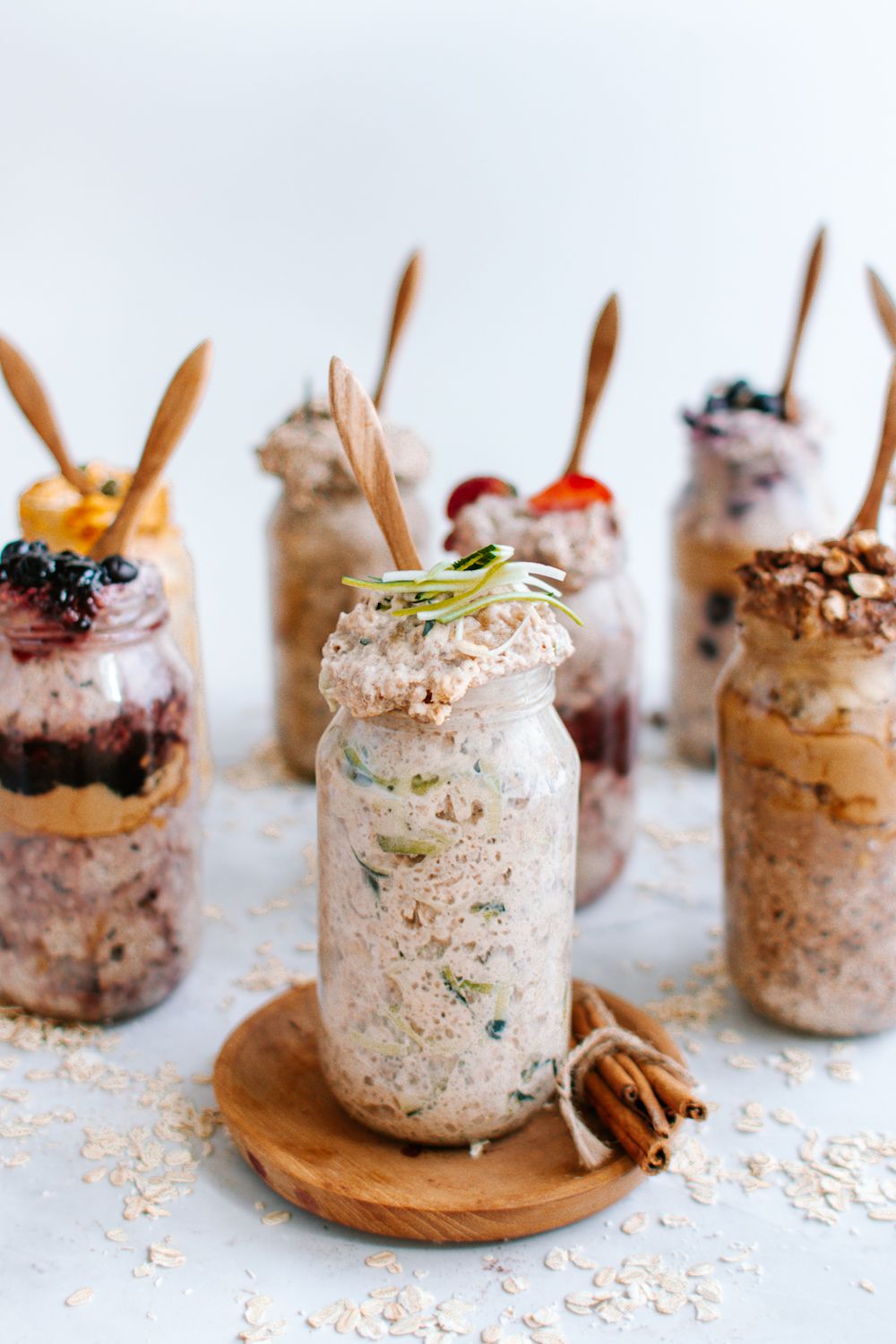 Overnight oats with zucchini in a glass jar with other flavors of oats in the background.