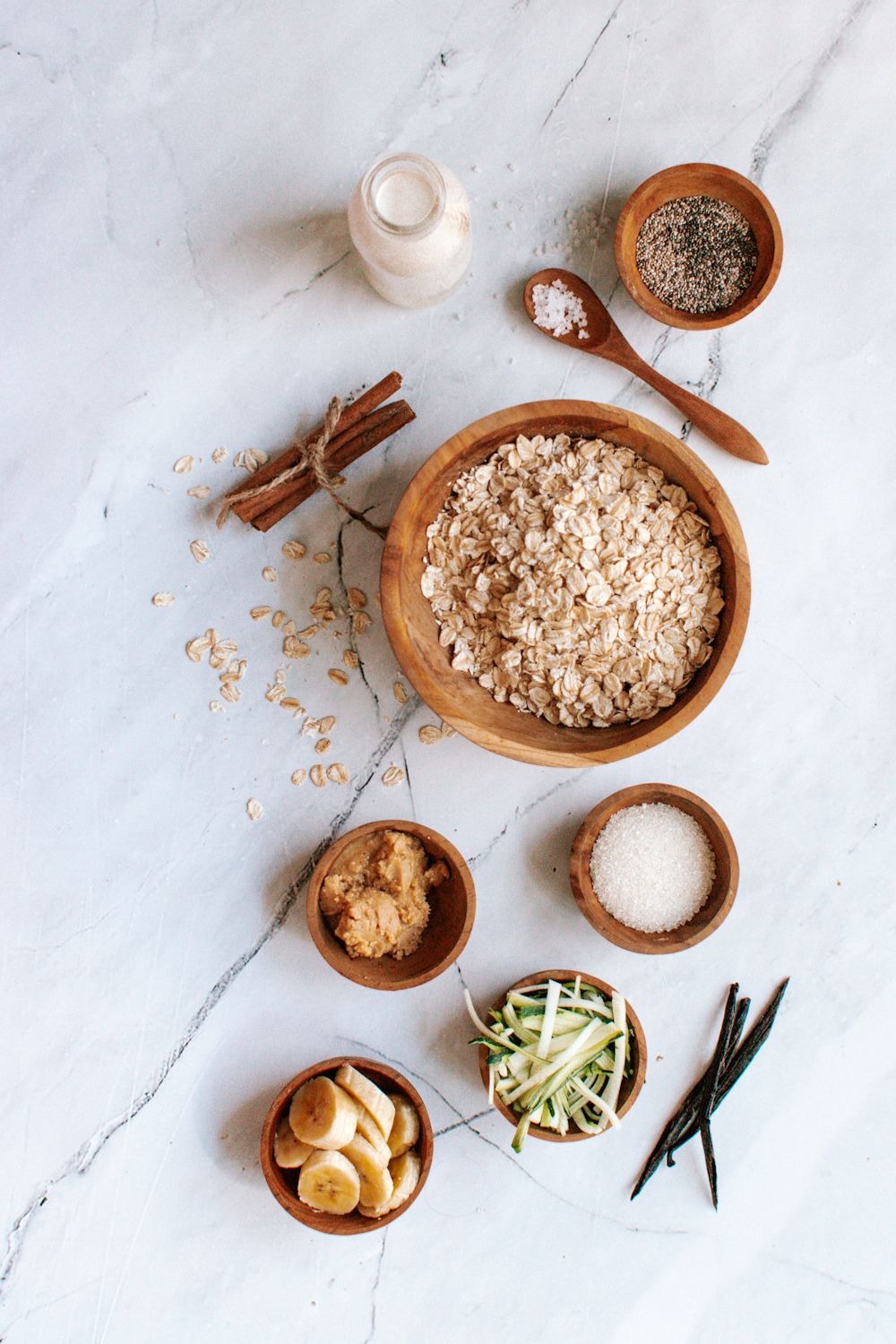 Zucchini oatmeal ingredients including rolled oats, shredded zucchini, almond butter, cinnamon, and vanilla.