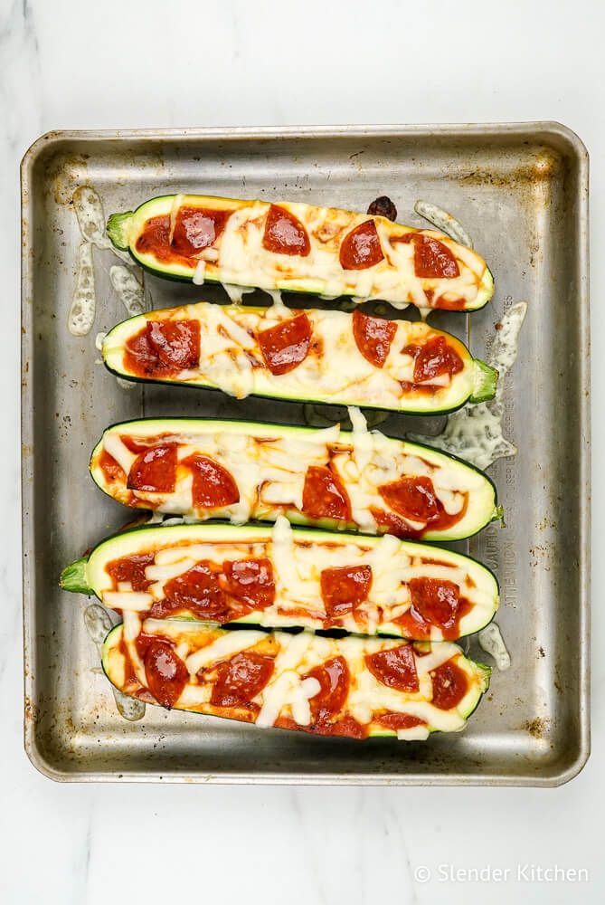 Zucchini pizza cooked on a baking sheet with pepperoni and mozzarella cheese.