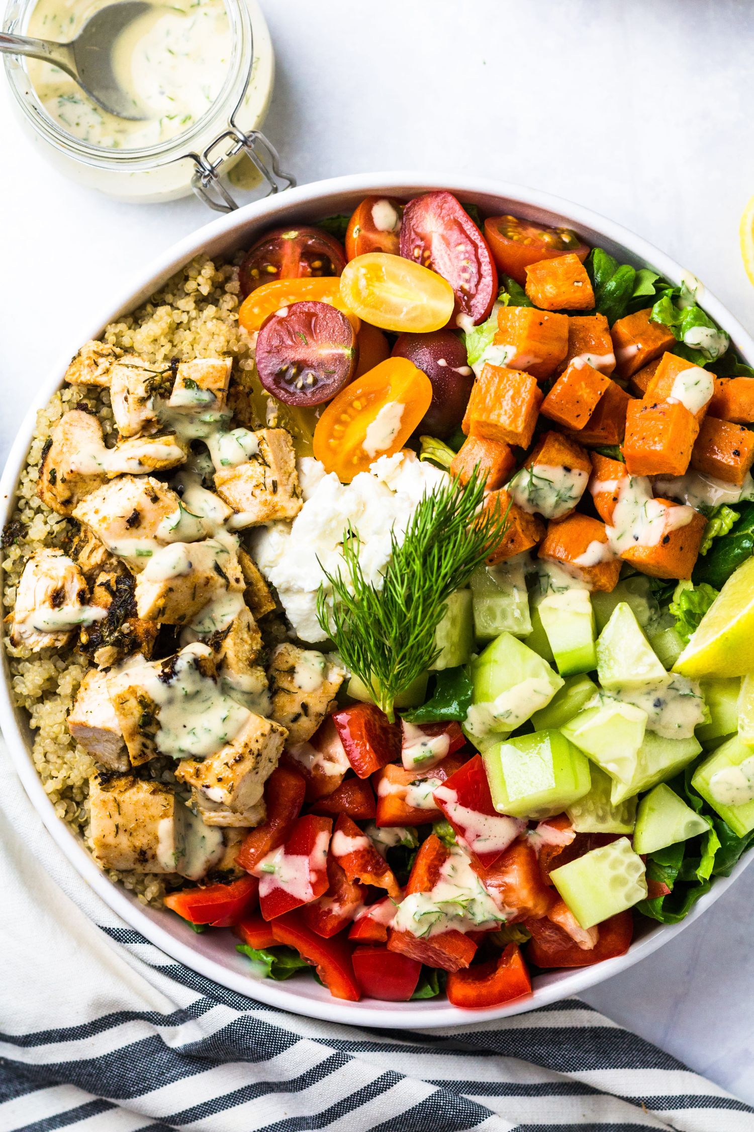 Chicken Mediterranean bowl with cucumbers, red peppers, quinoa, tomatoes, dill, and feta cheese.