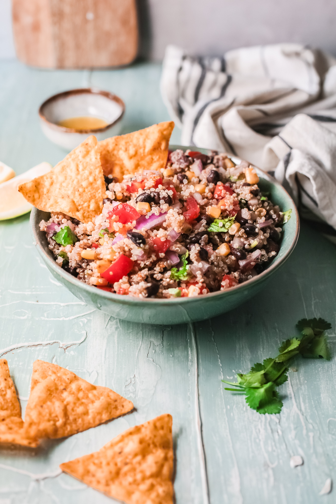 Healthy Mexican Quinoa in a bowl with cilantro, avocado, and tortilla chips.