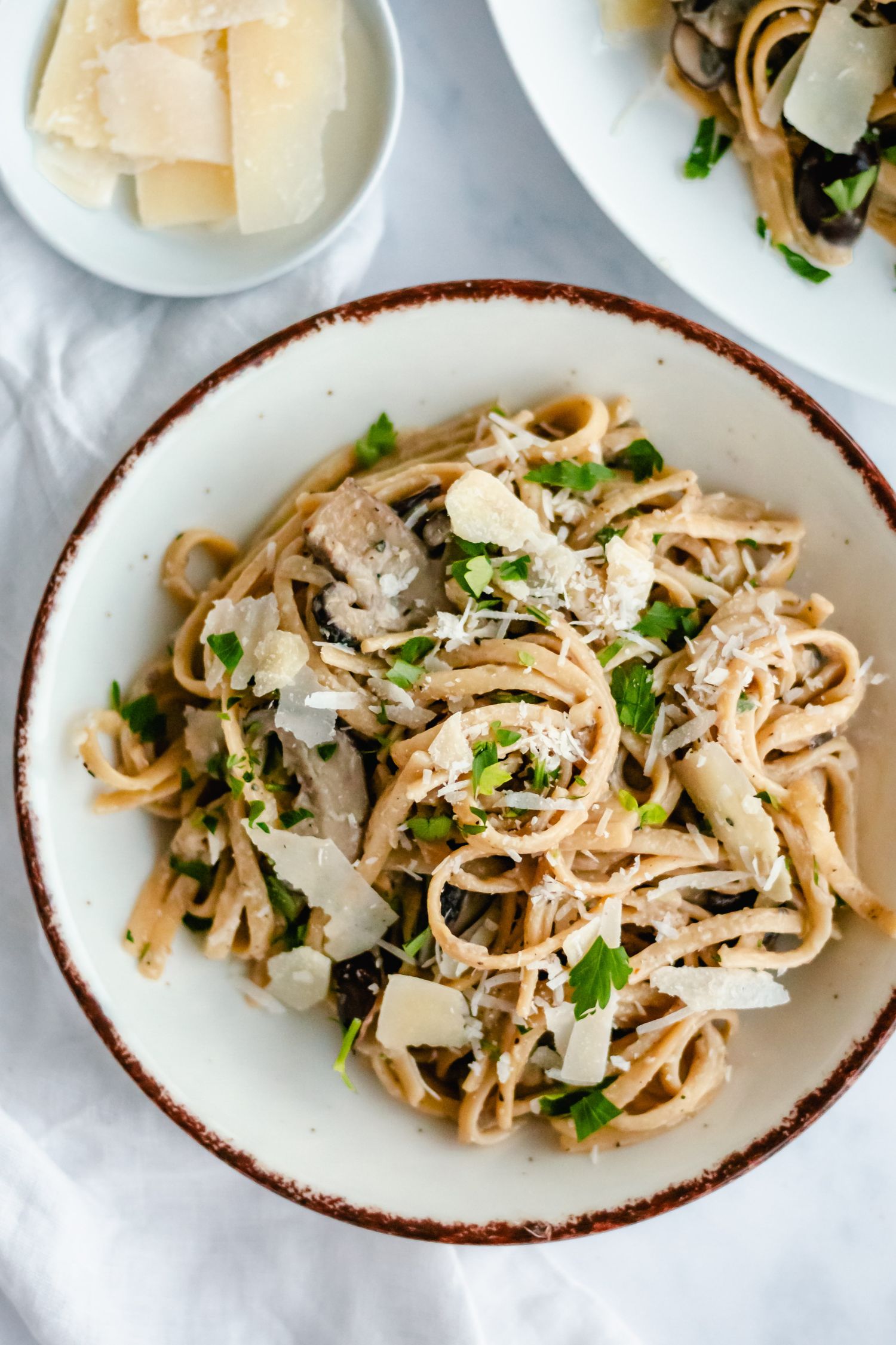 Bowl of creamy mushroom pasta with parsley and Parmesan cheese.