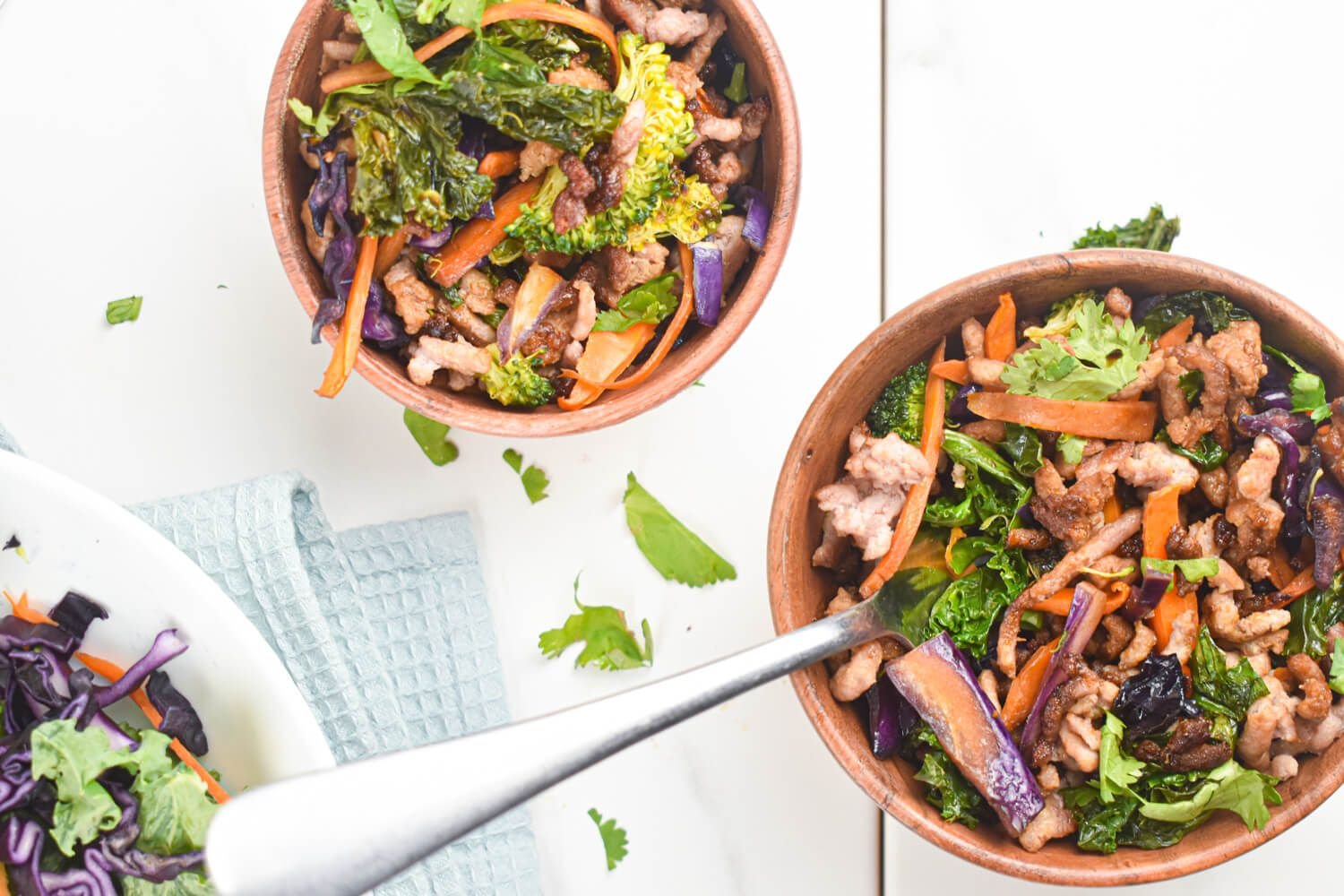 Asian ground turkey stir fry with fresh vegetables and ground turkey in two wooden bowls.