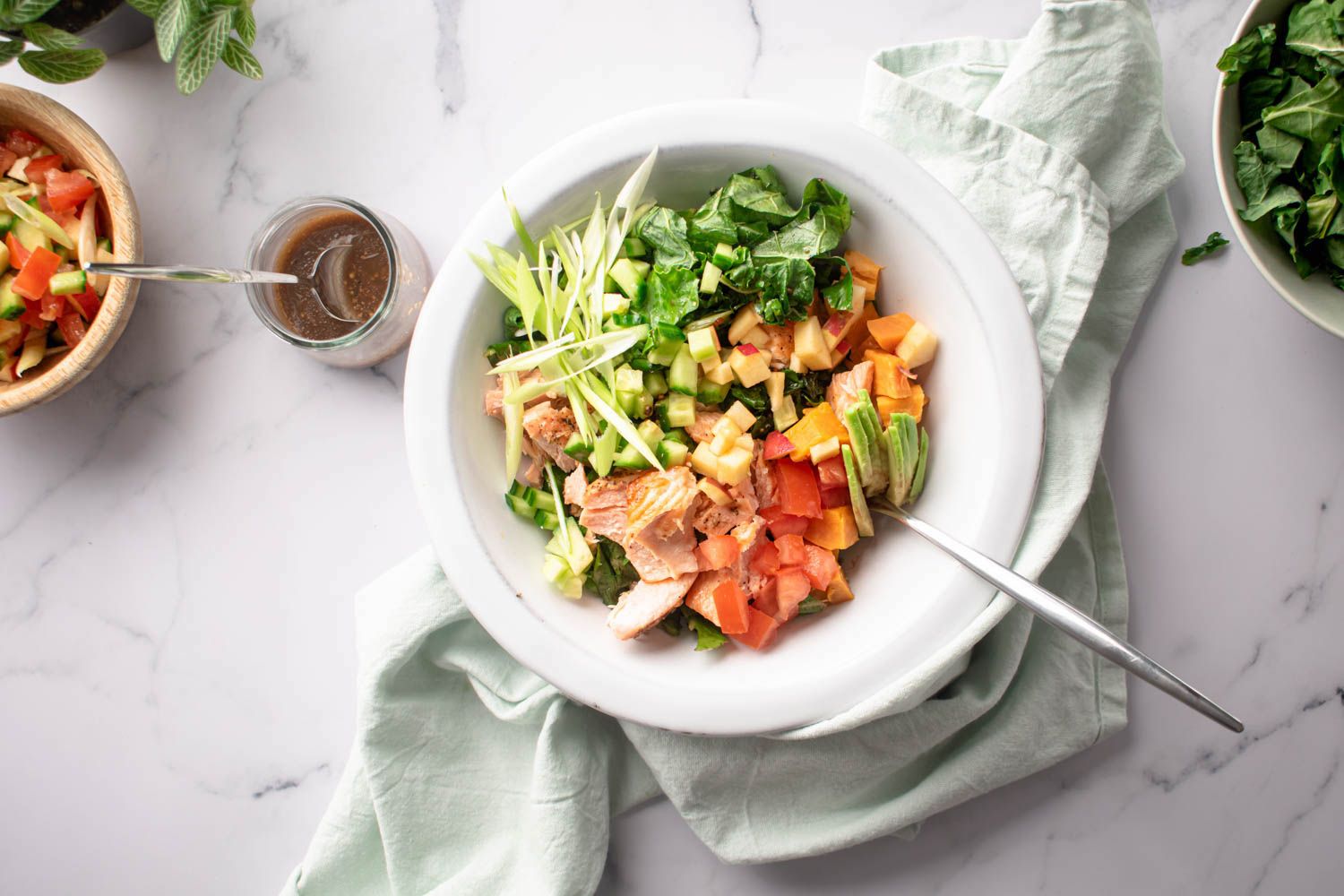 Salmon, kale, and sweet potato salad with tomatoes, apples, and a homemade vinaigrette.