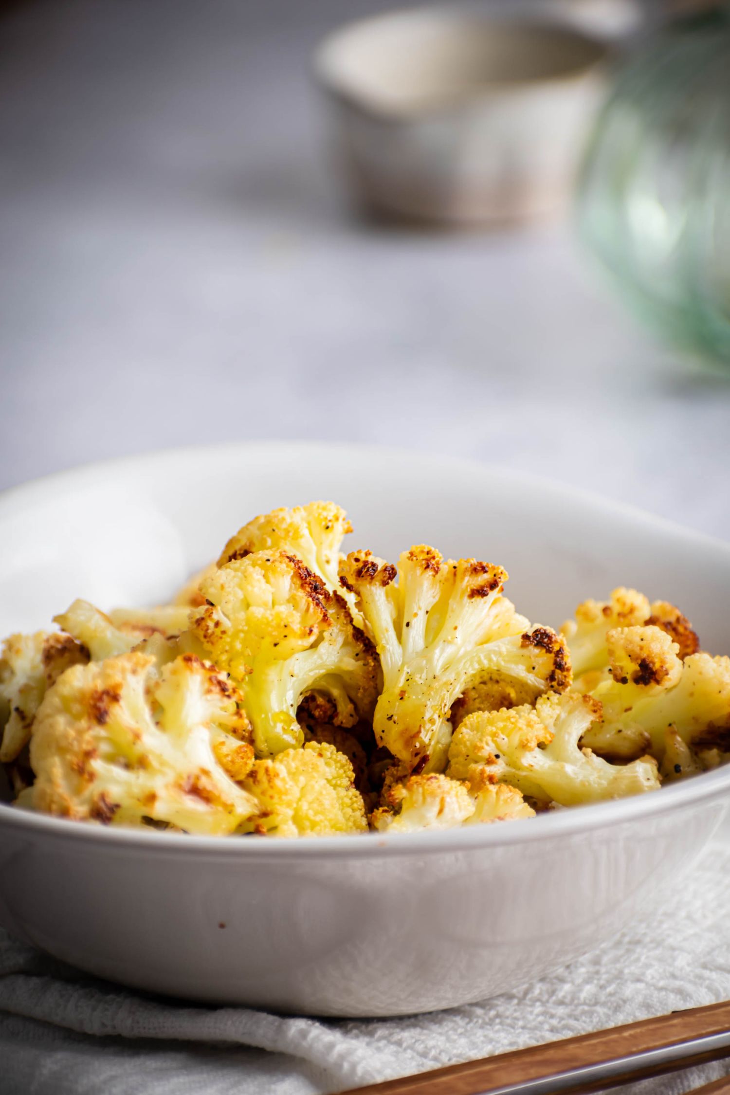 Crispy cauliflower florets that have been roasted in the oven served in a bowl.