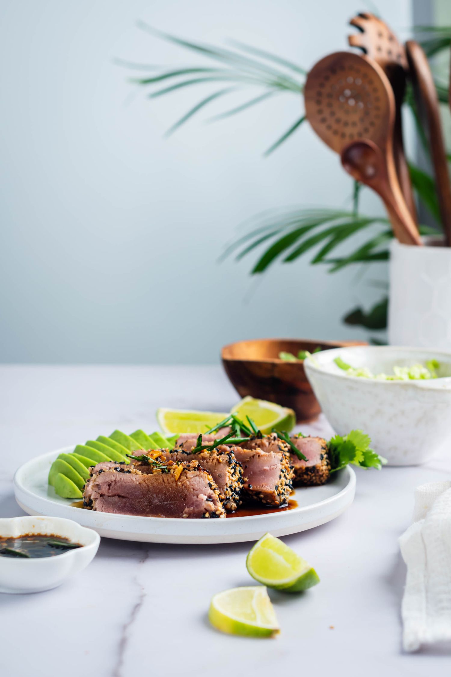 Ahi tuna coated with sesame seeds and seared rare served with avocado, soy dipping sauce, and limes.