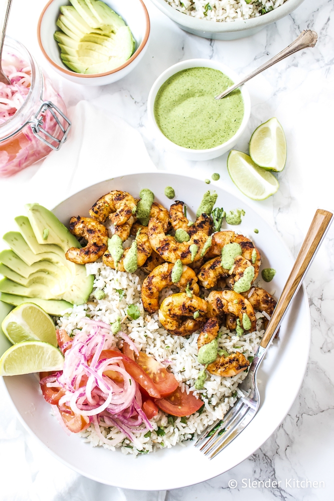 Easy shrimp an rice bowls with tomatoes, onions, limes, and cilantro sauce. 