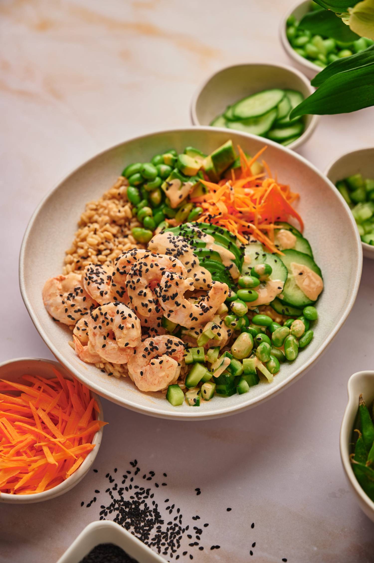 Sushi shrimp bowls with edamame, cucumber, rice, carrots, and sesame seeds. 