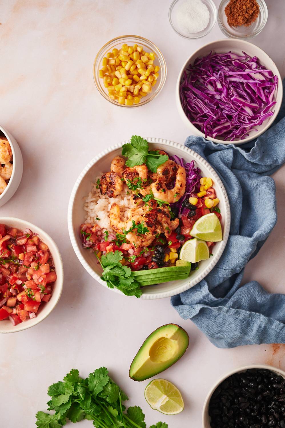 Easy shrimp taco bowls served with rice, black beans, cabbage, lime, corn, and cilantro.